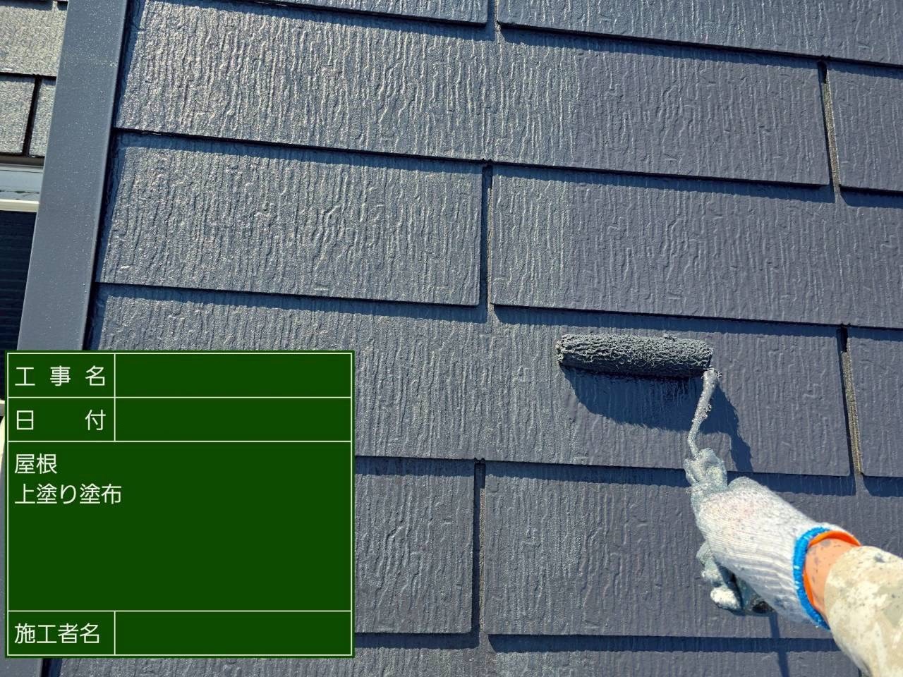 上塗りとして黒色の塗料をスレート屋根に重ね塗り